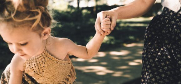 Mother holding child's hand signifying the importance of life insurance